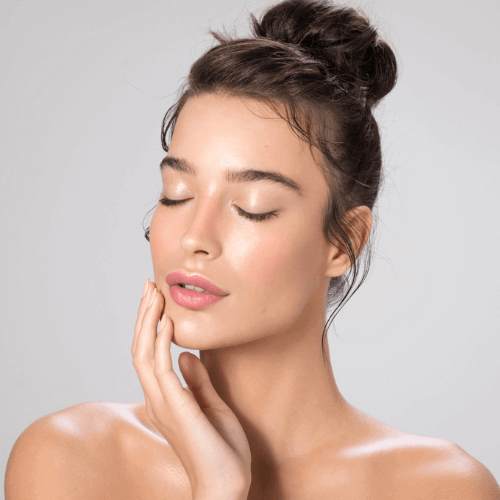 Woman with lip fillers closing her eyes and touching her face.